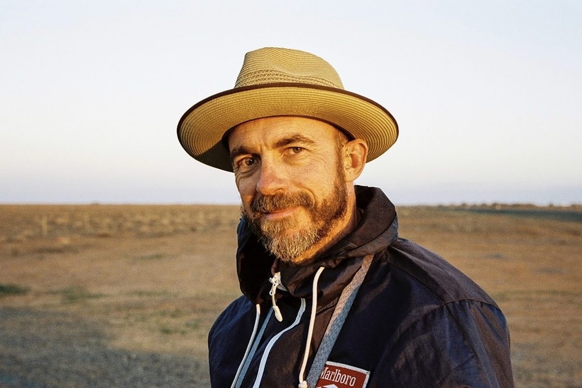 Dan, in a wide-brimmed hat, on open dry country at last light.